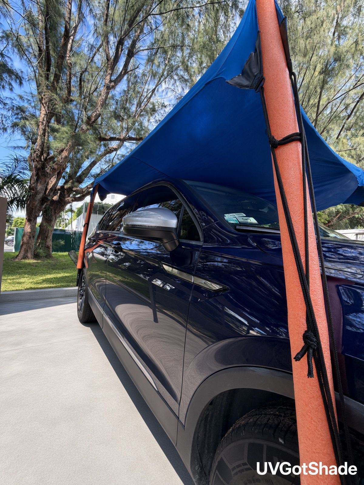 Blue stretch canopy cinched to a padded corner pole with tension cords
