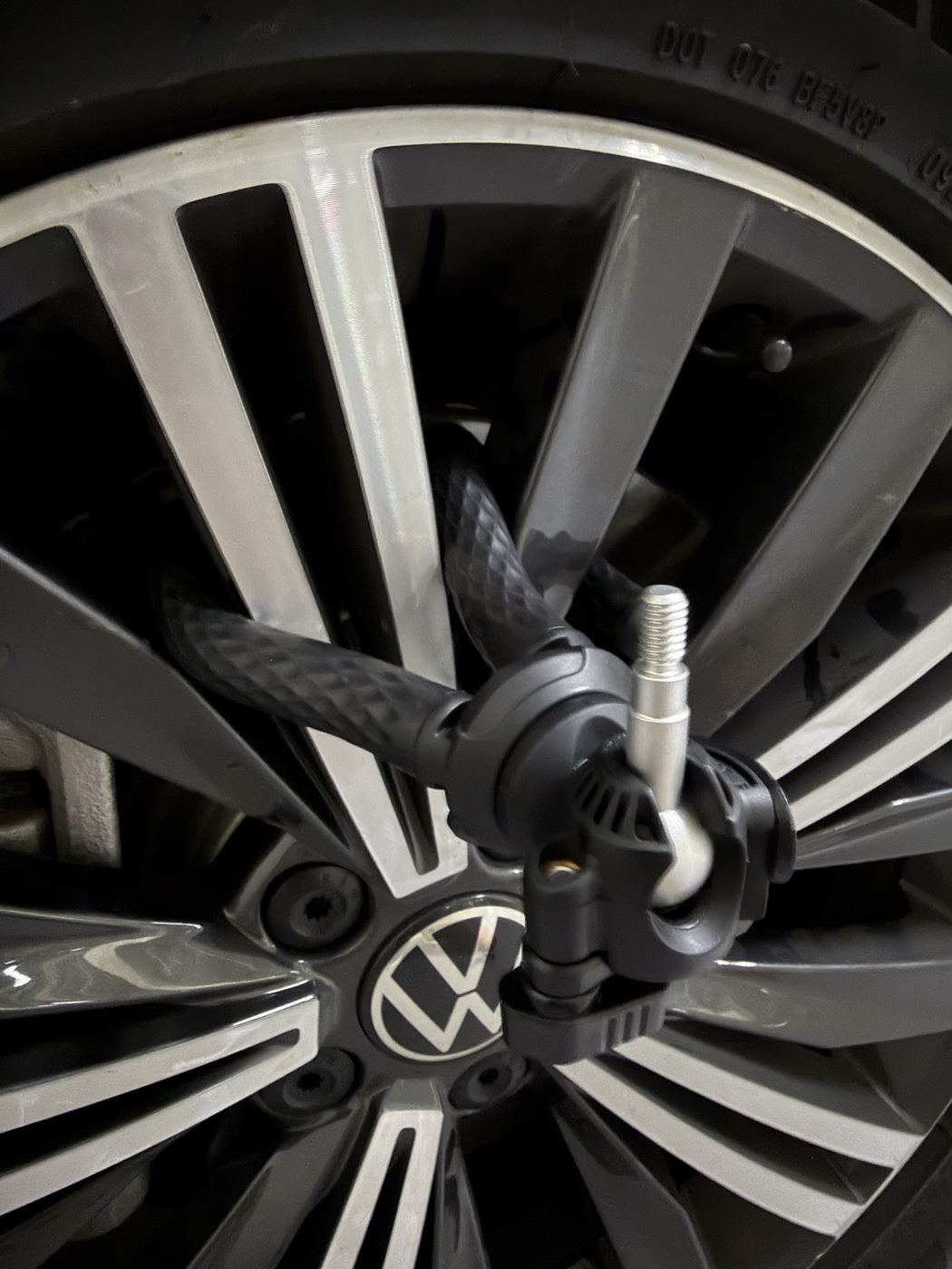 Flexible rubber tripod mount wrapped through the spokes of an alloy wheel