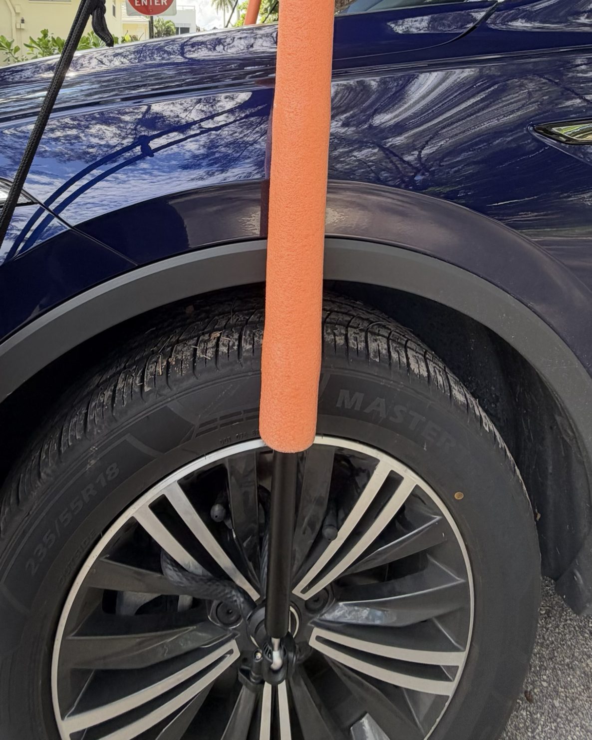 Aluminum pole rising from the wheel-hub mount, foam sleeve covering it alongside the fender